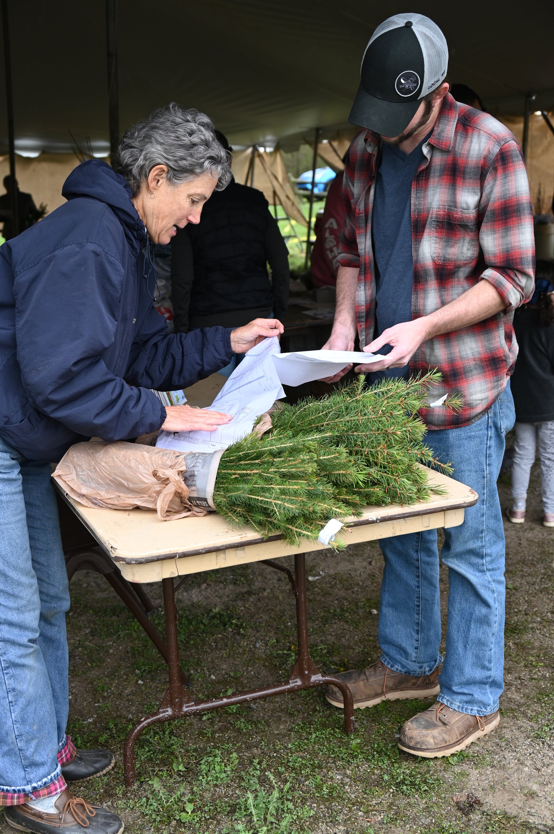 A volunteer double checking an order to a resident that ordered seedlings.